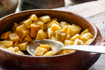 Portion of fried Cassava inside traditional crock pot in Brazilian country kitchen
