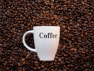 Top view of roasted coffee beans with a mug. Coffee lovers