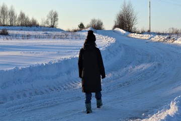 Winter, snow, a girl goes on the road.