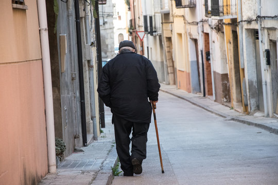 Abuelo paseando por la calle en soledad