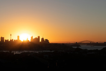 Naklejka premium sydney skyline at sunset. sun behind the skycraper.