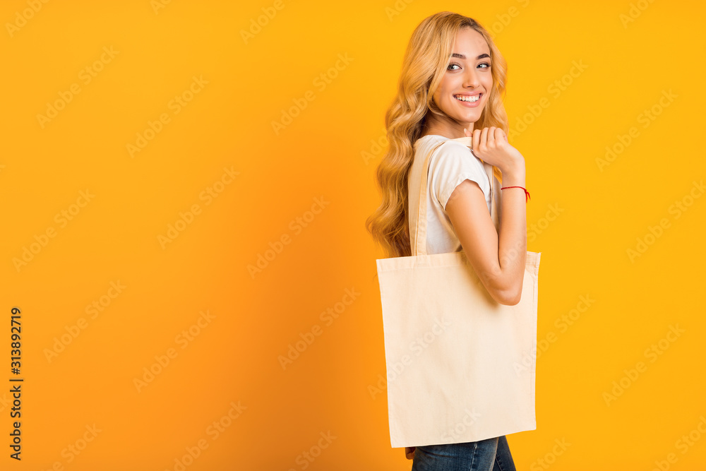 Wall mural stop plastic pollution. girl with blank eco bag