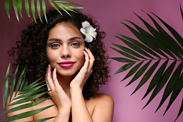 Beautiful woman with with light make up and curly hairstyle wearing shoulderless dress.
