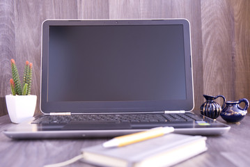 notebook on the table with vase and cactus
