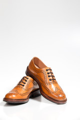 Footwear Concepts. Full Broggued Tan Leather Oxfords Shoes Isolated On White Background.
