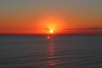 Primeros momentos del amanecer sobre un mar en calma y con el reflejo del sol sobre el agua