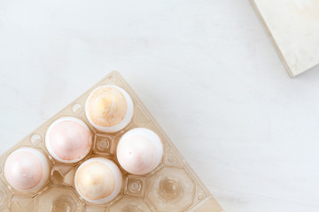 Natural Colored silver and gold  Eggs in egg box. Compositions in pastel colors. Easter concept. Flat lay, top view, selective focus 