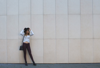 Fototapeta premium Young girl with a black hat posing at a checkered wall
