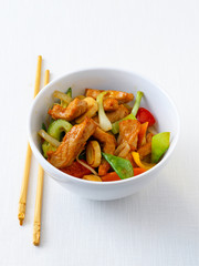 Asiatisch gebratene Hühnerbrust mit Gemüse in einer Schale mit Stäbchen