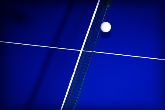 background with ball for table tennis over a table in blue with white lines