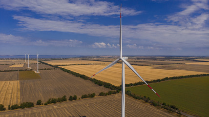 Windmill in the middle of a field. View from the drone. Agriculture and technology.