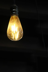 Yellow light bulb isolated on black background 6 vertical