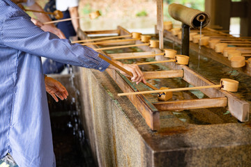 Woman with traditional ladle in Buddhist temple