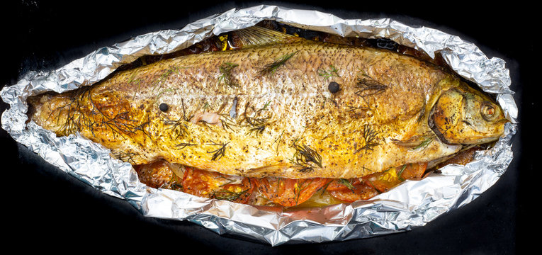 baked big fish with vegetables in foil