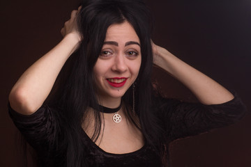 brunette on dark background dressed in goth style