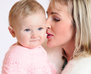 Close-up of a woman snuggling nose to a child