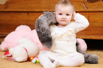 Cute child in knitted baby clothes on floor