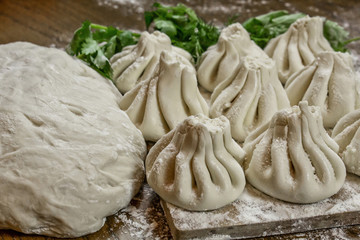 Fresh khinkali made from dough with meat inside, a national Georgian dish. Fresh dough, flour and herbs.