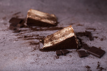Traditional italian dessert tiramisu.  Some pieces on the table are scattered and chocolate. top view