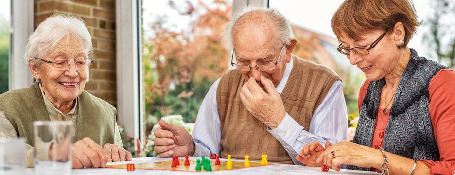 Elderly Couple and Daughter Playing Board Game