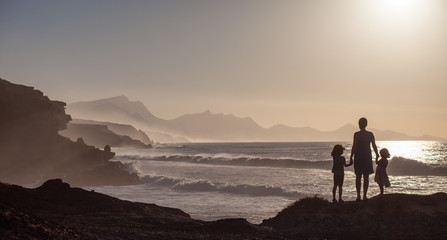 Fototapeta premium A woman with her children on holiday at Playa De La Pared, Fuerteventura, Canary Islands, Spain