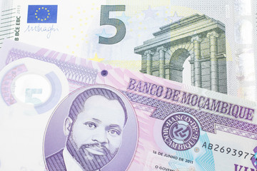 A purple, twenty metical note from Mozambique close up with a red, one hundred European euro note
