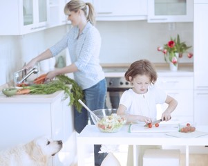 Mother and Daughter (8-9) preparing healthy meal in kitchen