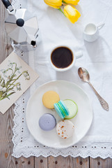 Fototapeta na wymiar Breakfast with French colorful macarons with coffee cup