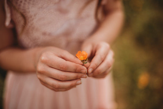 Girl holding an orange flower
