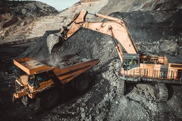 High angle view of excavator loading coal in dumper truck