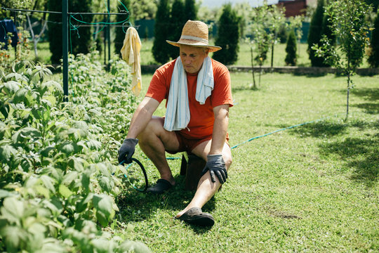 A man sitting on the chair and watering garden