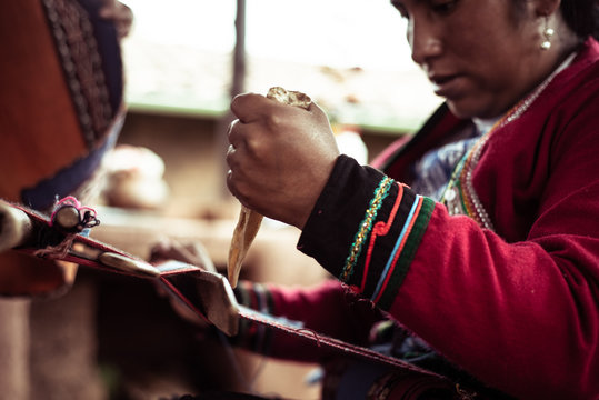Woman weaving alpaca wool with bone