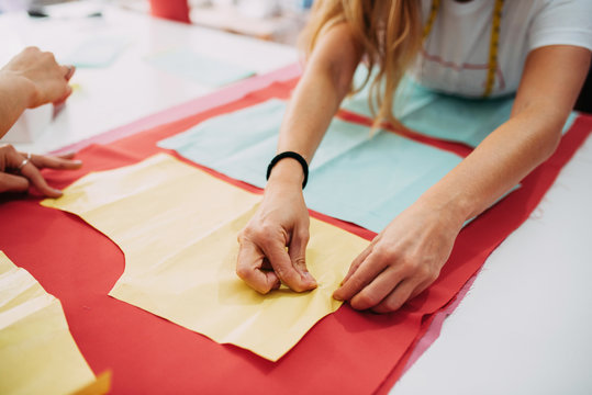 Fashion designer preparing fabric to cut