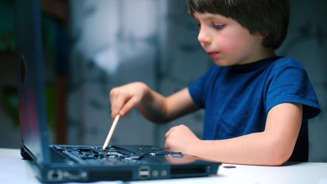 boy forcefully removes the keys from the laptop, causing damage as he breaks the computer in frustration or anger. Destruction of the computer, rendering it inoperable. removal of the keys damage