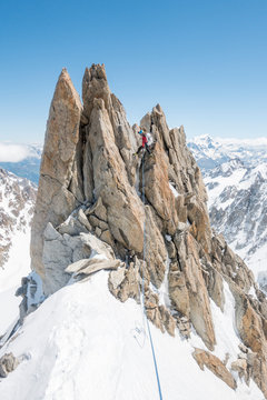 A seasoned alpinist rappels a spectacular gendarme on the Forbes Ridge
