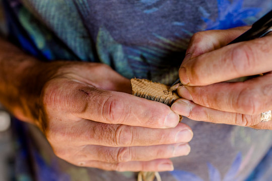 Close-up of artist's hands signing autograph on finished project