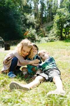 Closeup view of three young children hugging on a summer day