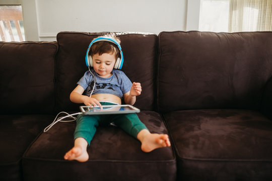 Young boy happily using tablet to play educational games at home