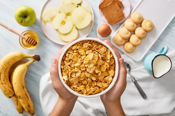 Man holding bowl of cereals. Rich breakfast ingredients. Top view