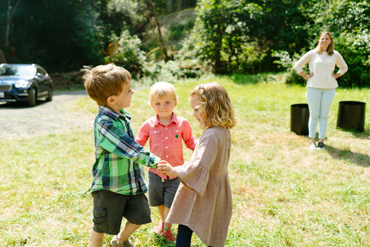Portrait of three children holding hands and playing together