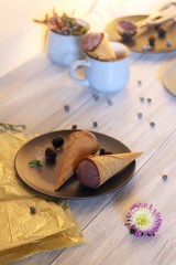 Homemade chocolate ice cream in waffle cones, berries on a wooden table, healthy dessert