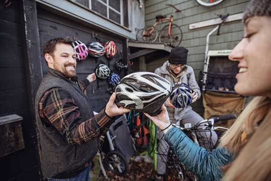 A Young Man Passes Out Bike Helmets At A Bike Rental Shop