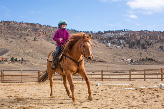 Girl loping her horse in an outdoor arena