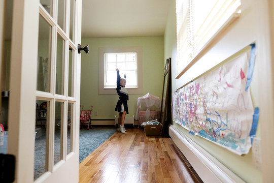 girl in cheerleading uniform practicing in front of mirror