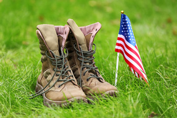 Military boots and USA flag outdoors. Memorial Day celebration
