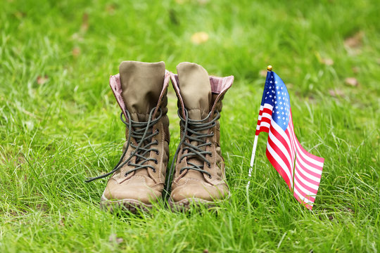 Military boots and USA flag outdoors. Memorial Day celebration