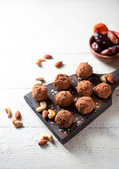 Delicious homemade energy balls with dried apricots, dates, prunes, walnuts, almonds and cashews in coconut and cocoa. Vegan and vegetarian raw snack or meal.