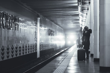 crying girl with a suitcase on the subway platform