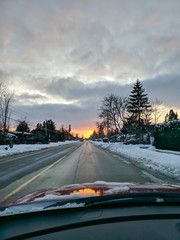 View out car window down snowy road.