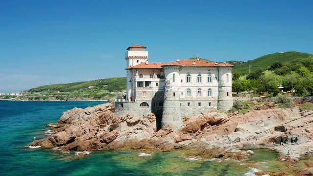 Boccale Castle perched on seaside cliff on Etruscan coast, Aerial pan 